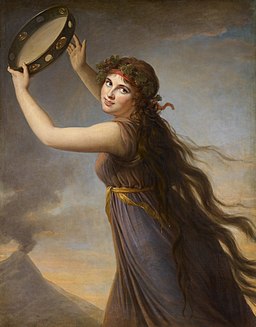 'Portrait of Emma, Lady Hamilton as a Bacchante'. Painting by Elizabeth Vigée le Brun. Image shows a young woman with long hair dressed in a classical robe and hodling a tambourine aloft. 