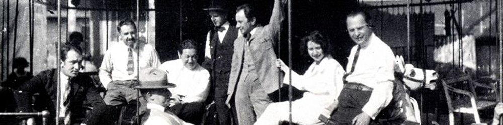 The Waxworks cast and crew relax with friends and colleagues on the film's carousel set. Paul Leni is seated fourth from left, facing the camera. From L-R: Wilhelm (William) Dieterle, Ali Hubert, E. A. Dupont, Leni, Fritz Maurischat, John Gottowt, Lore Sello, Leo Birinski. (Image: Wikimedia Commons)