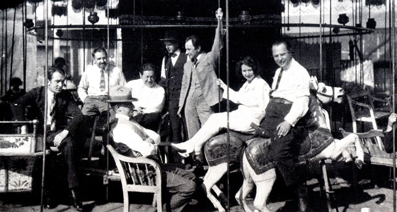 The Waxworks cast and crew relax with friends and colleagues on the film's carousel set. Paul Leni is seated fourth from left, facing the camera. From L-R: Wilhelm (William) Dieterle, Ali Hubert, E. A. Dupont, Leni, Fritz Maurischat, John Gottowt, Lore Sello, Leo Birinski. (Image: Wikimedia Commons)