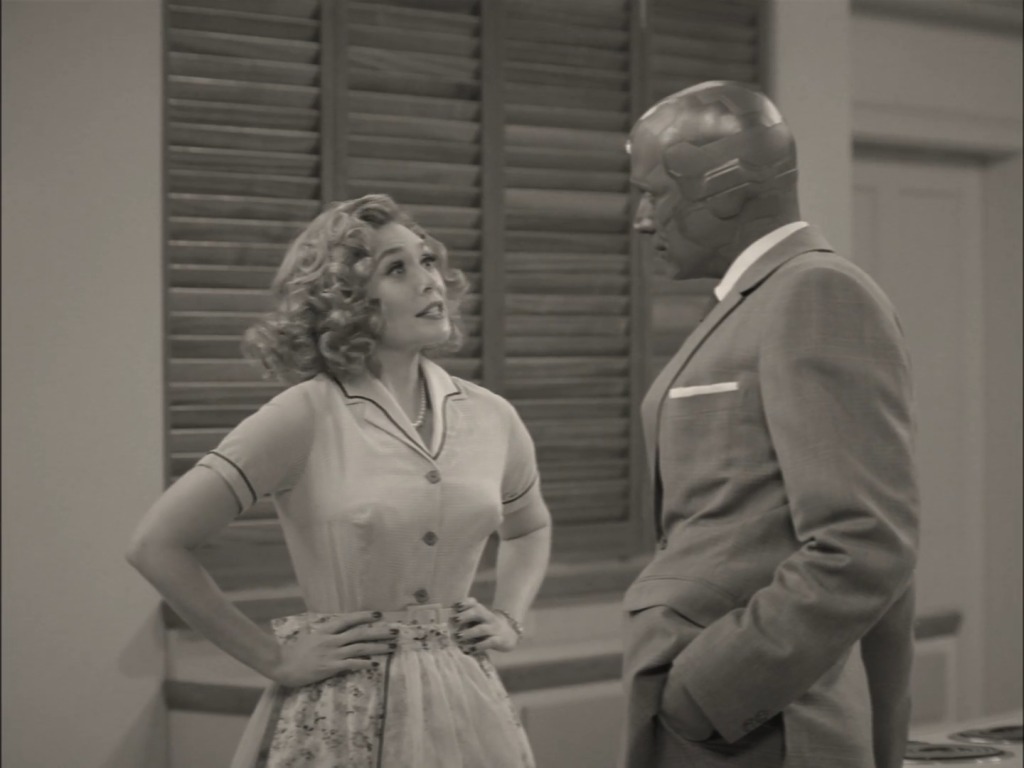 Domestic bliss? Vision and Wanda appear in WandaVision’s unusual setting. Photo: from Marvel Studios/Disney+ Wandavision (2021). A black and white screenshot from the TV show Wandavision showing Wanda (a woman in a 1950s outfit) and Vision (a robotic man in a suit).