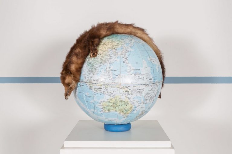 A fur rug is draped over a globe