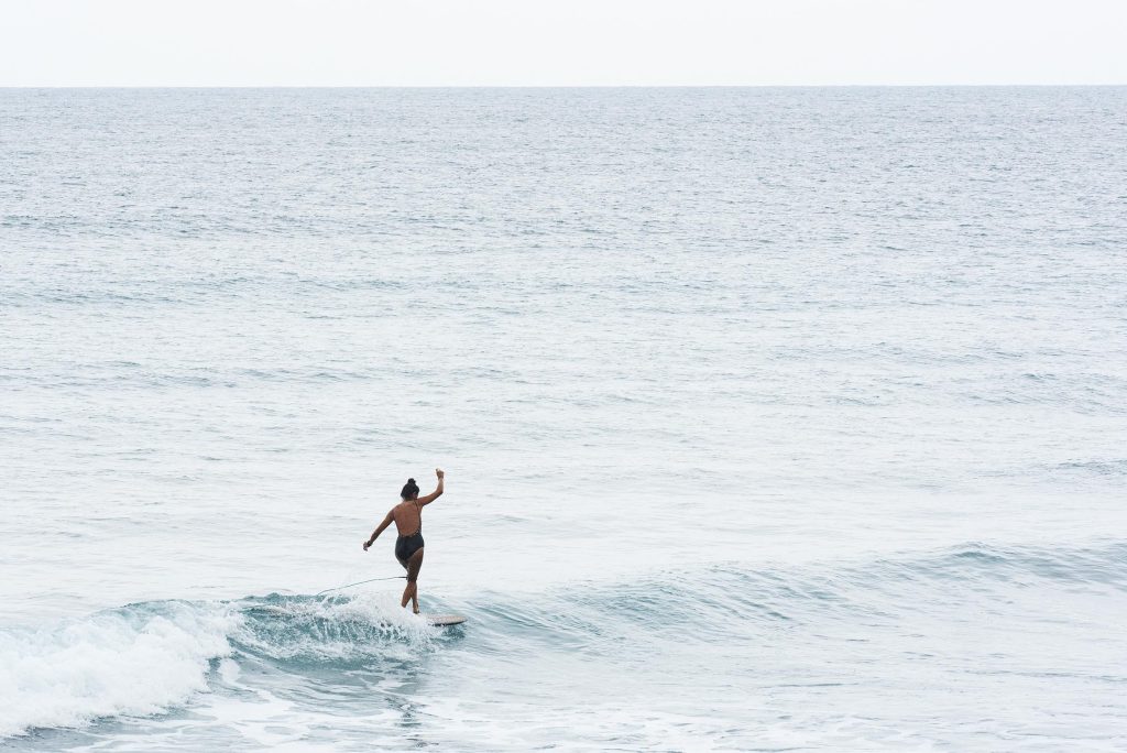 A woman is on a surfboard at sea