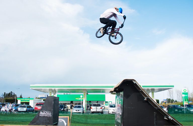 A woman on a dirt bike jumps over a ramp