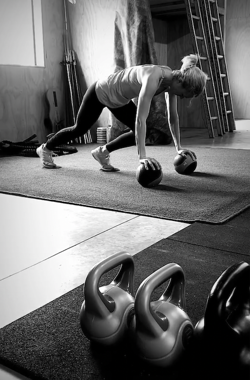 A woman is doing press ups in a gym