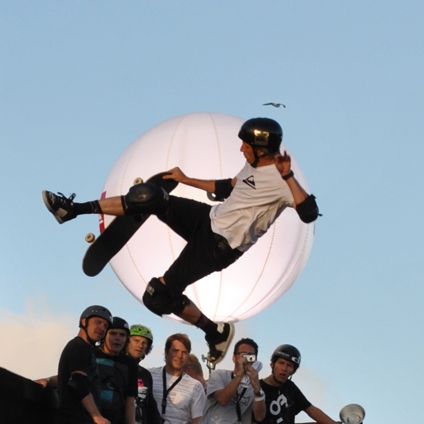 A man doing a skateboard trick in front of a crowd