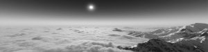 A black and white photo of the sun above a mountaintop