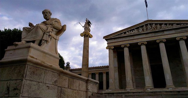 A statue of Plato in front of an Athens government building