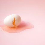 A cracked egg against a pink backdrop from Unsplash