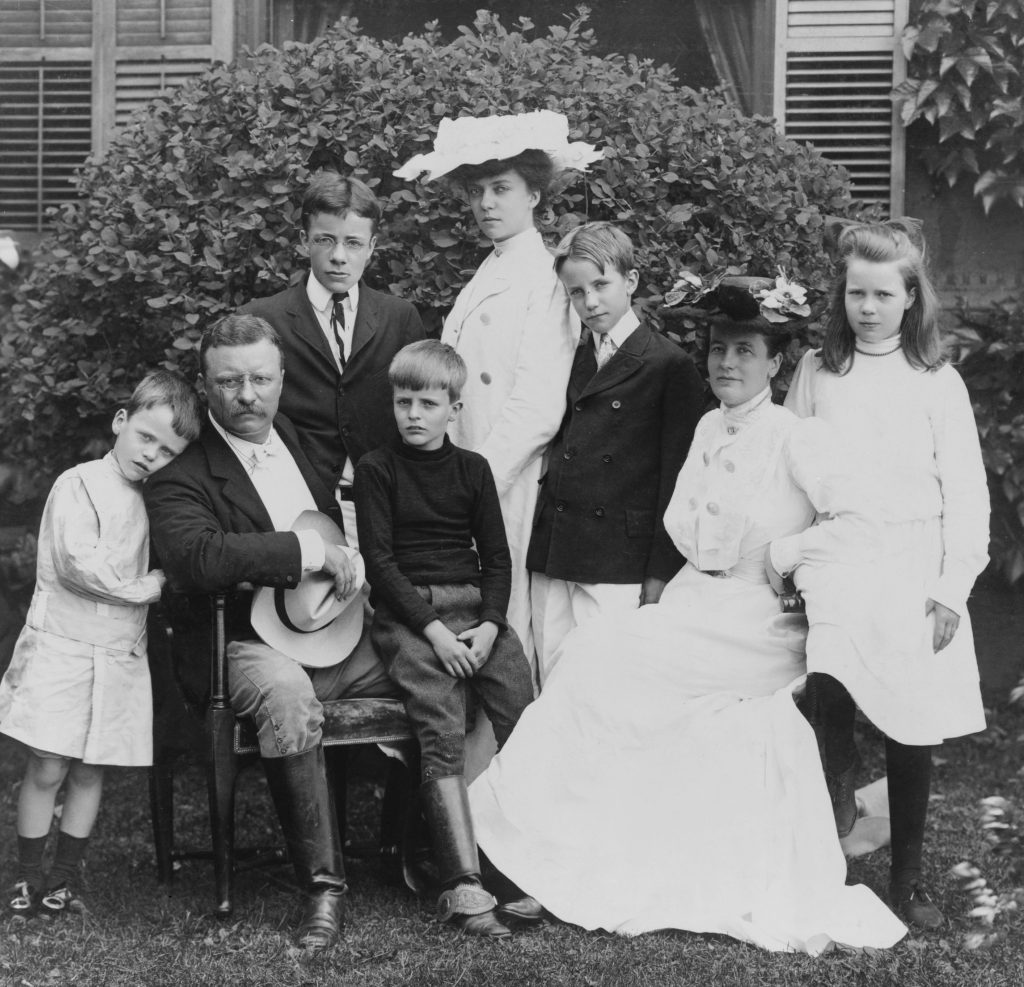 A black and white photo of Theodore Roosevelt surrounded by his family