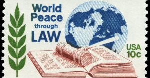 An embroidery of a globe, and an open book, with the words 'World Peace Through Law'