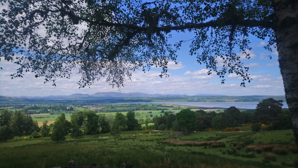 A photo overlooking fields with a small village visible in the background