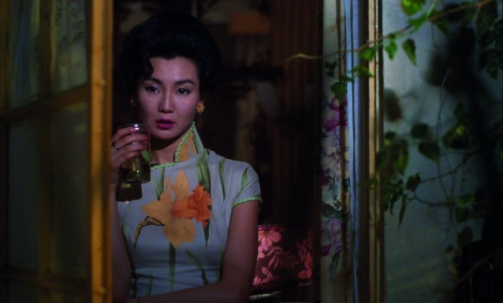 A film shot of actress Maggie Cheung dressed in traditional Asian clothing and holding a glass