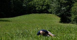 A person laying down in a field of grass