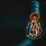 A lightbulb filament lit up against a dark background