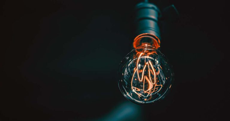 A lightbulb filament lit up against a dark background