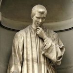 A photograph of the statue of Machiavelli in Florence: he has his hand raised to his chin in thought