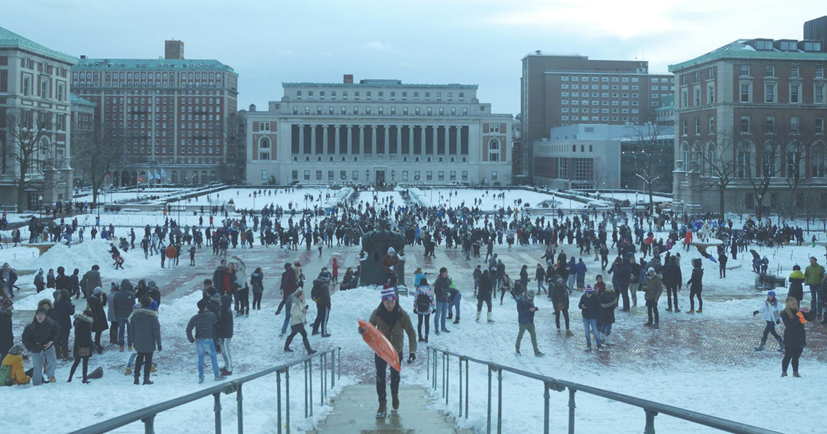 Photograph of Columbia University in the snow, with crowds of people enjoying the weather