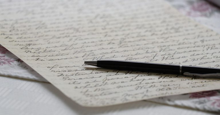 Photograph of a handwritten letter with a pen lying across it