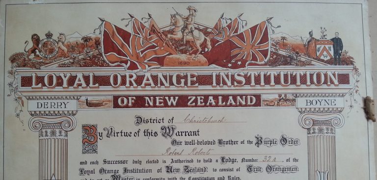 Certificate with text contained within two pillars, and a ceiling showing Union Jack flags and a man on horseback. The text reads 'Loyal Orange Institution of New Zealand. District of Christchurch. By virtue of this Warrant our well-beloved brother of the Purple Order Robert Roberts and each Successor duly elected is Authorised to hold a Lodge, number 32A, of the Loyal Orange Institution of New Zealand, to consist of True Orangement and to act as Master in conformity with the Constitution and Rules.