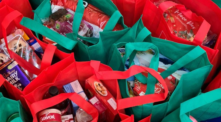 Red and green shopping bags full of groceries.