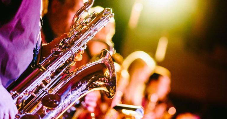 close-up photograph of a saxophonist playing with a band