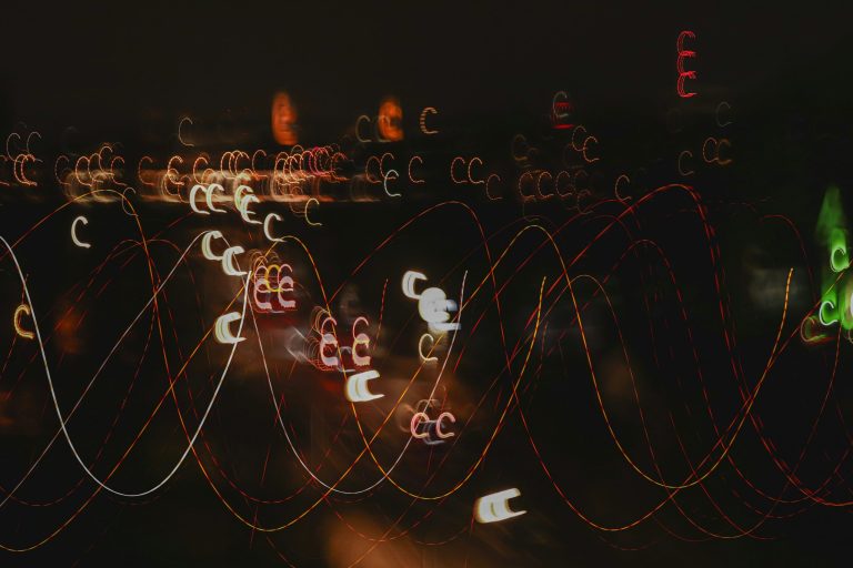 A blurry photograph of a city after dark, made up of the lights of the city against a dark backdrop