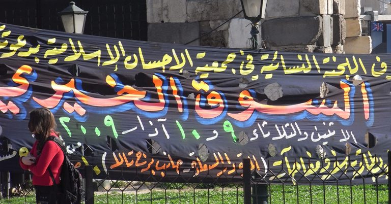 photograph of a black banner with colourful writing advertising a charitable market