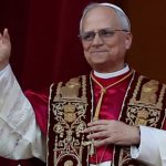 Pope Leo stands on a balcony waving