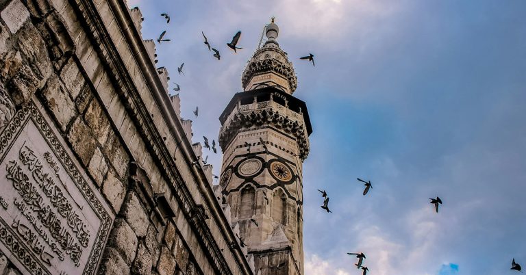 Photograph taken from below of ornate old architecture rising into the sky