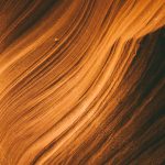 Layers of orange waves fade into a dark background