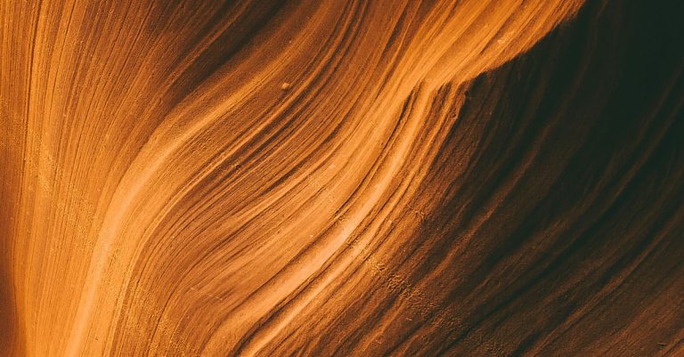 Layers of orange waves fade into a dark background