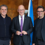 John Swinney with the Mayors of Liverpool City Region and Greater Manchester. Swinney is standing in the middle, with the mayors either side. They are all smiling and looking straight ahead.