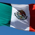 The Mexican flag flying in the wind.