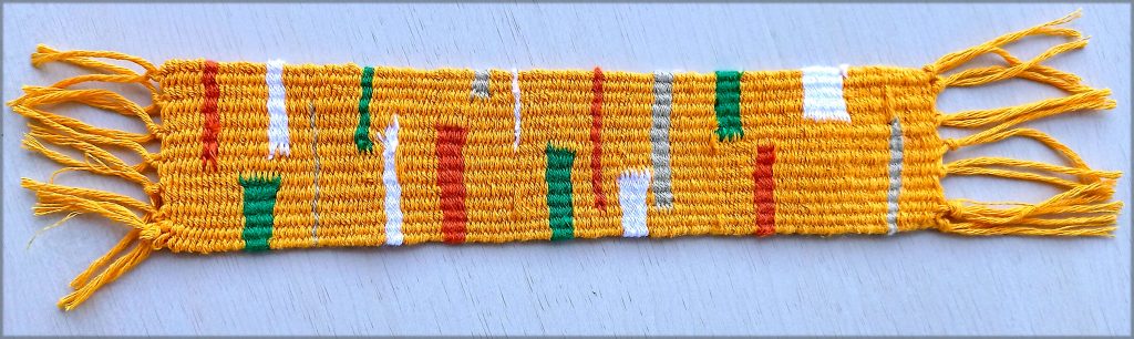 A vibrant, multicoloured woven textile with complex geometric patterns and varied textures.