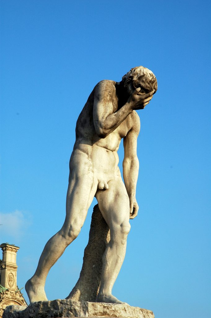 Statue of a woman with hands over her face denoting shame