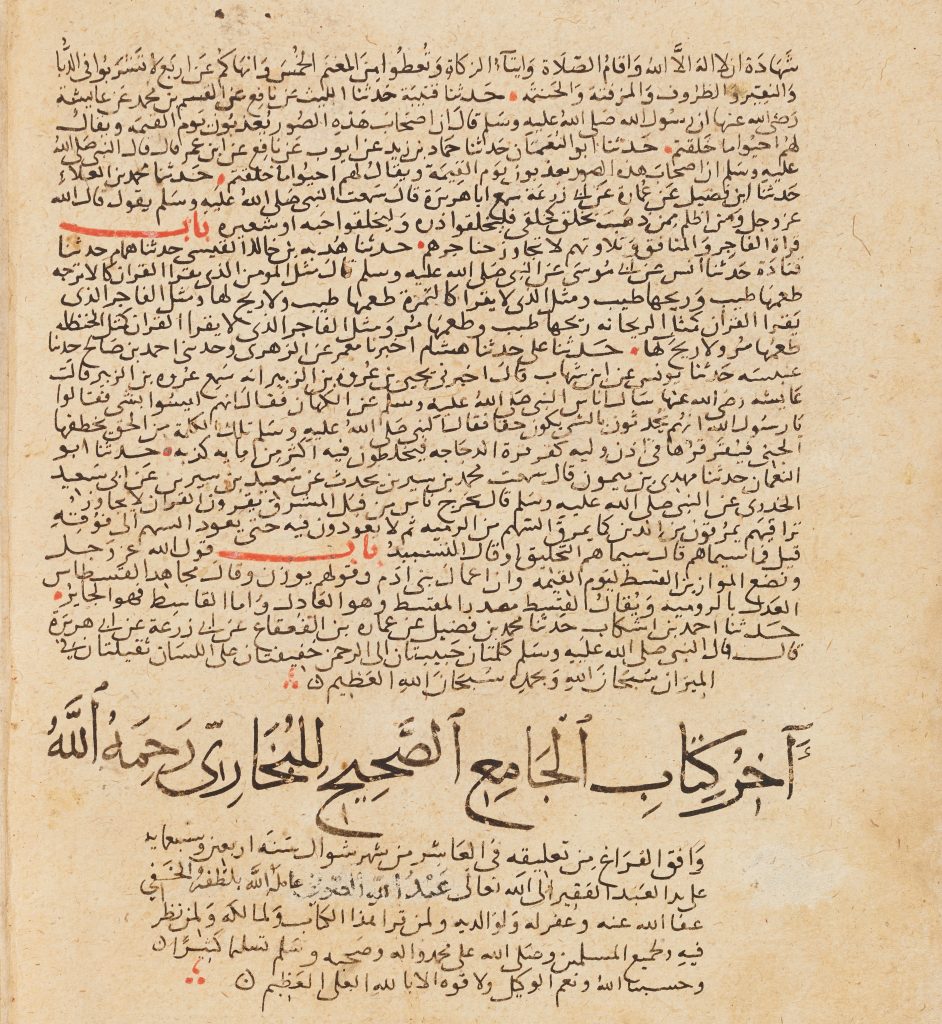 A photograph of an aged Arabic manuscript page written in black ink on yellowed parchment, with red annotations and markings highlighting certain words and passages.