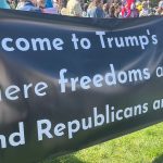 Protestors at a “No Kings” protest in Boston in 2025 hold up a sign, reading “Welcome to Trump’s America where freedoms are gone and Republicans are silent.”