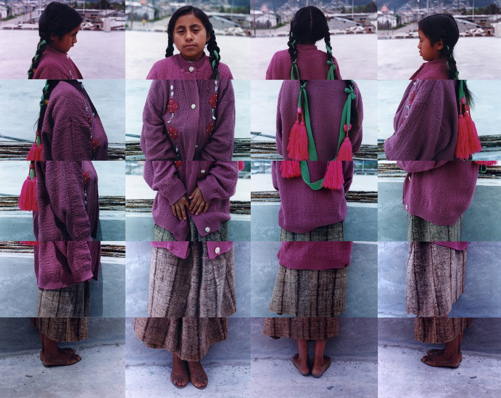 This photo collage features a young indigenous Latin American girl shown from multiple angles in eight photographs arranged in a 4x2 grid. She wears a purple cardigan, brown skirt, and worn leather sandals, with bare feet. Her dark braided hair is adorned with bright pink tassels tied to ribbons, gathered at the back with a green ribbon. The images alternate between front and back views, her expressions subtly shifting—sometimes meeting the camera, sometimes looking away, quiet and serious yet not unhappy. The consistent background shows a plain concrete surface, possibly a rooftop or wall, with a blurred cityscape in the distance.